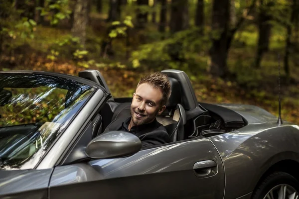 Élégant jeune homme heureux en voiture convertible en plein air . — Photo