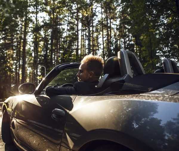 Elegante jonge gelukkig man in converteerbare auto buiten. — Stockfoto