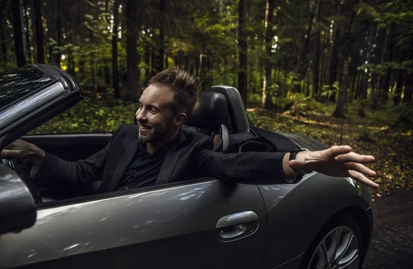 Elegante giovane uomo felice in auto convertibile all'aperto . — Foto Stock