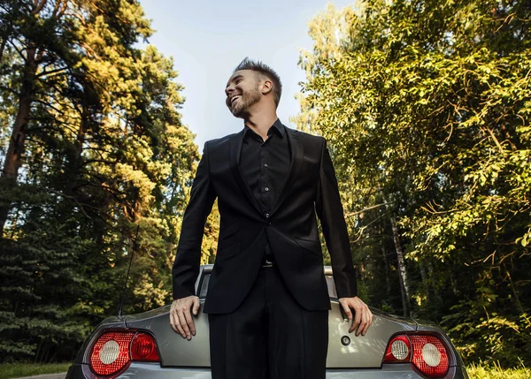 Elegante jovem homem feliz no carro conversível ao ar livre . — Fotografia de Stock