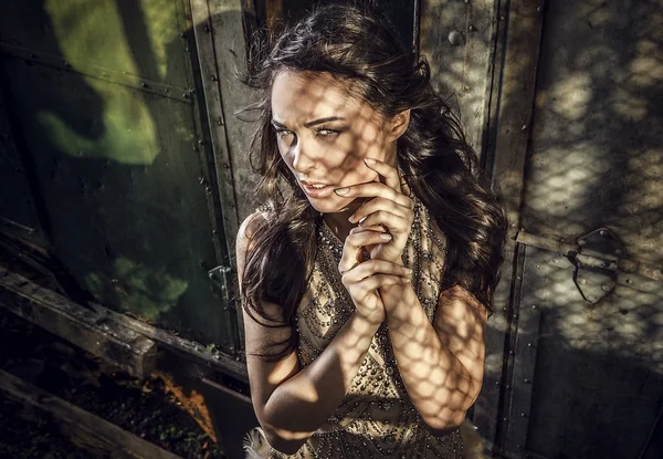 Imagem dramatizada de sensual & atraente jovem mulher em vestido de luxo posando ao ar livre . — Fotografia de Stock