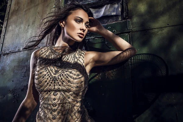 Gedramatiseerde beeld van sensuele & aantrekkelijke jonge vrouw in luxe jurk poseren buitenshuis. — Stockfoto