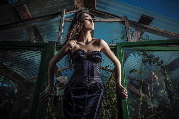 Gedramatiseerde beeld van sensuele & aantrekkelijke jonge vrouw in luxe jurk poseren buitenshuis. — Stockfoto