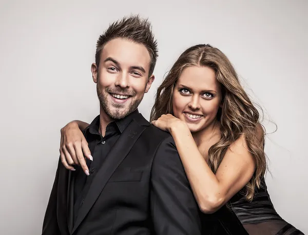 portre Studio içinde siyah moda kıyafetler giymiş poz genç çekici çift.