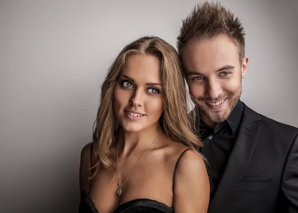 Retrato de jovem casal atraente posando no estúdio vestido com roupas de moda preta . — Fotografia de Stock