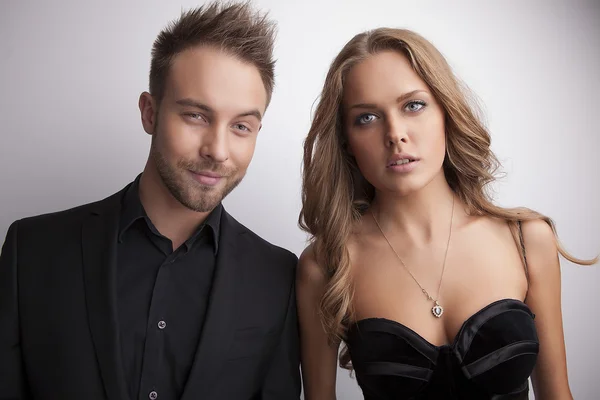 Portrait of young attractive couple posing at studio dressed in black fashionable clothes. Stock Photo