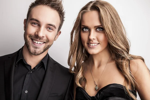 Portrait of young attractive couple posing at studio dressed in black fashionable clothes. Royalty Free Stock Images