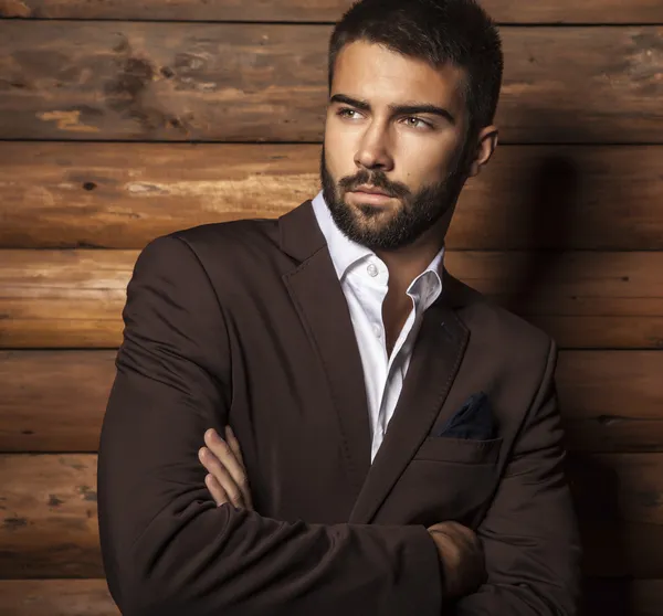 Portrait of young beautiful fashionable man against wooden wall. — Stock Photo, Image