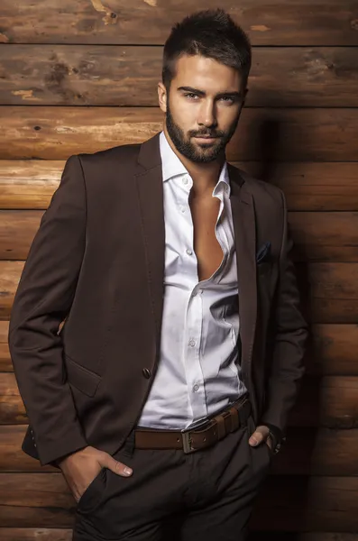 Retrato de joven hermoso hombre de moda contra la pared de madera . —  Fotos de Stock