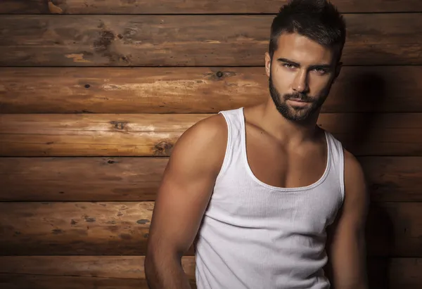 Portrait of young beautiful fashionable man against wooden wall. — Stock Photo, Image