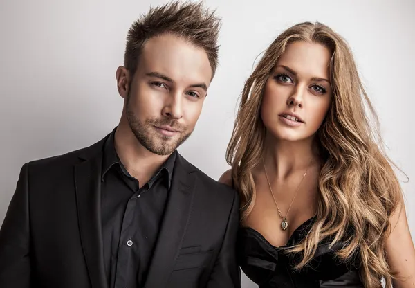 Portrait of young attractive couple posing at studio dressed in black fashionable clothes. — Stock Photo, Image