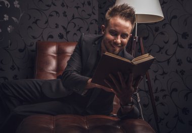 yakışıklı genç iş adamı lüks kanepede rahatlatıcı koyu elbiseli.