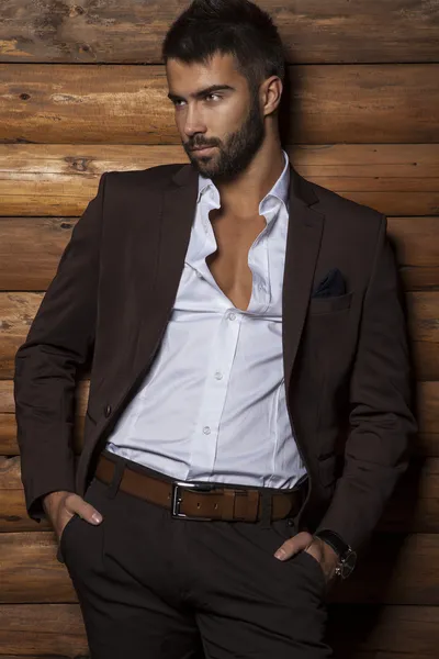 Retrato de joven hermoso hombre de moda contra la pared de madera . — Foto de Stock