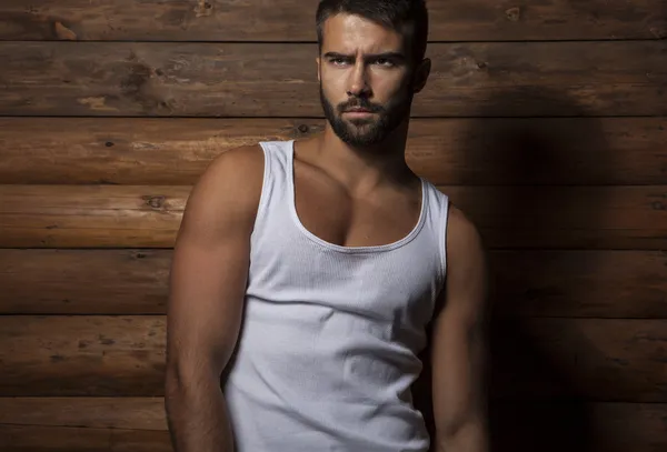 Retrato de jovem belo homem elegante contra a parede de madeira . — Fotografia de Stock