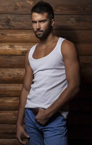 Retrato de joven hermoso hombre de moda contra la pared de madera . —  Fotos de Stock