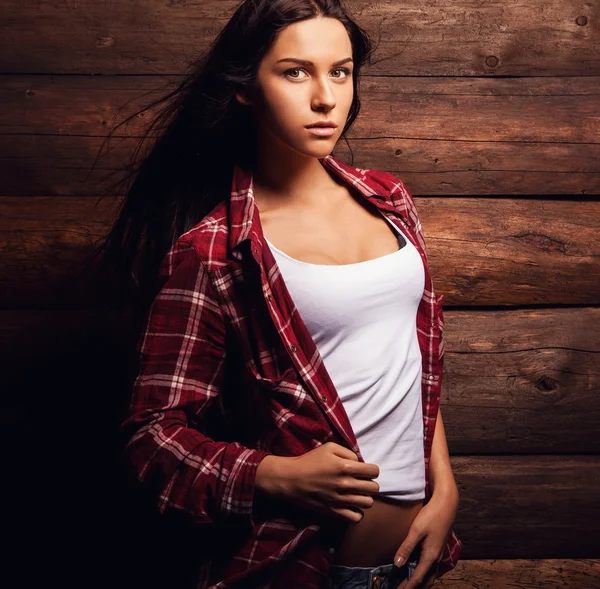 Jeune femme sensuelle & beauté en vêtements décontractés pose sur fond de bois grunge . — Photo