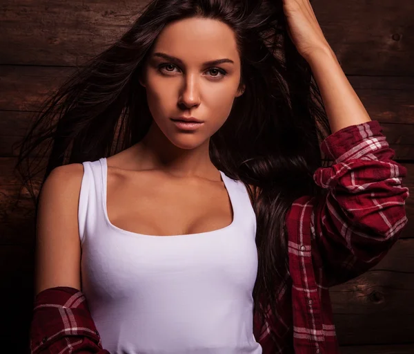 Giovane donna sensuale e di bellezza in abiti casual posare su sfondo di legno grunge . — Foto Stock