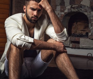 Beyaz elbiseli genç çekici sakallı erkekler modern odada poz vermek..