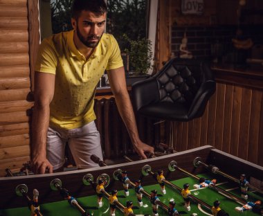 Sarı tişört üzerinde futbol oynayan genç yakışıklı adam.
