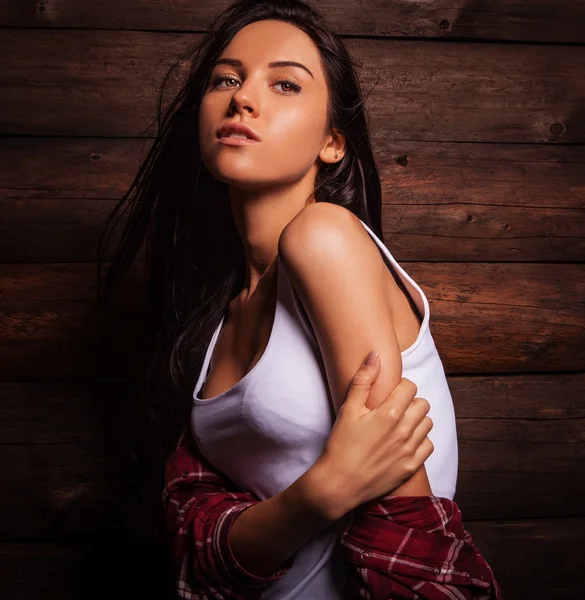 Junge sinnliche & schöne Frau in lässiger Kleidung posiert auf Grunge-Holzgrund. — Stockfoto