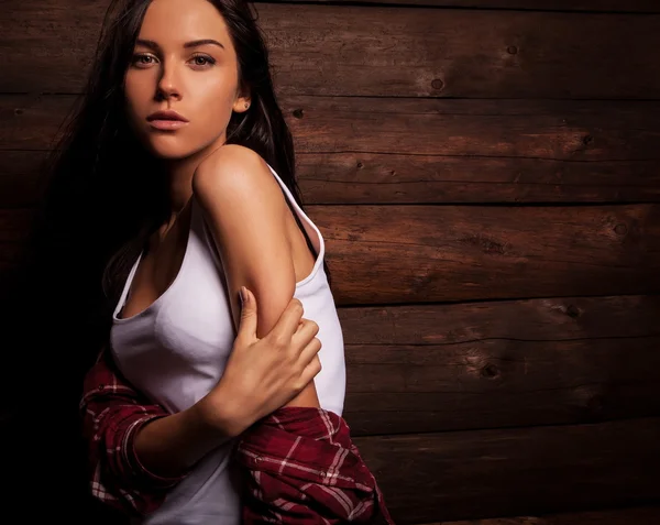 Jeune femme sensuelle & beauté en vêtements décontractés pose sur fond de bois grunge . — Photo