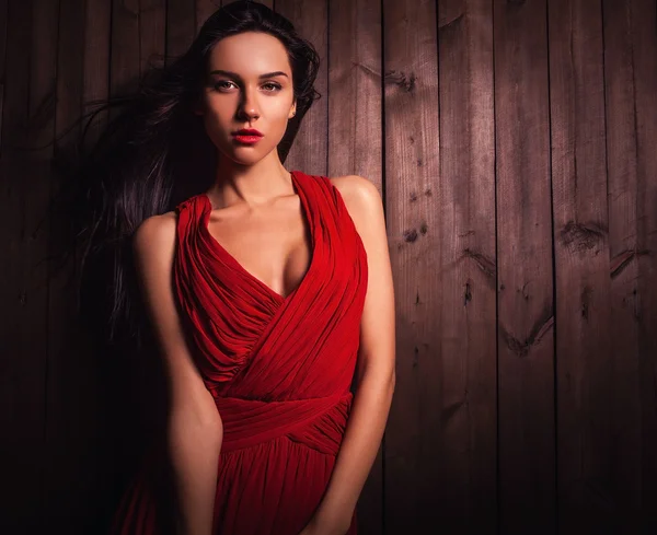 Lady in red pose on wooden background. Close-up photo. — Stock Photo, Image