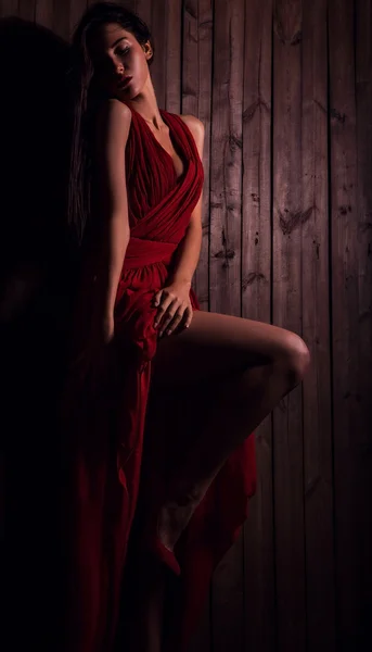 Lady in red pose on wooden background. Close-up photo. — Stock Photo, Image