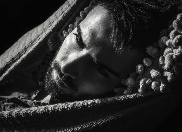 Retrato de un joven guapo y serio hombre en una hamaca. Foto de primer plano en blanco y negro . —  Fotos de Stock