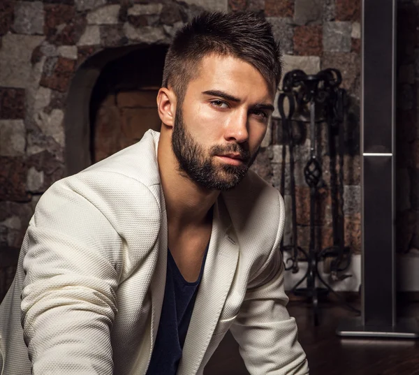 Young attractive bearded men in white suit pose in modern room. — Stock Photo, Image