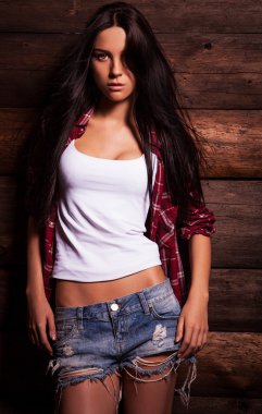 Genç şehvetli & güzellik kadın rahat kıyafetler poz grunge ahşap zemin üzerinde.