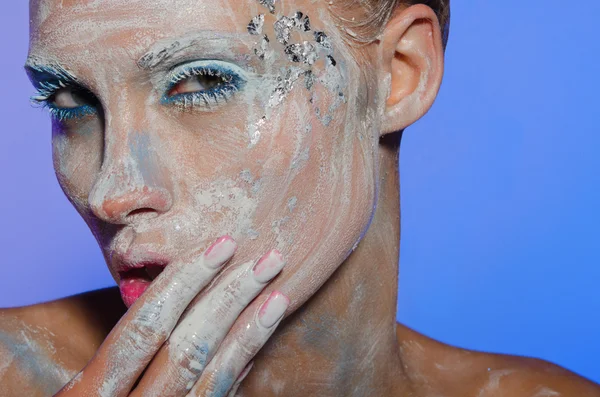 Young woman spreads over face paint — Stock Photo, Image