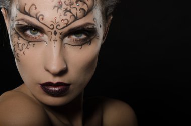 Yüzünde koyu bir dantel modeli olan kadın