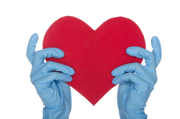 Två händer i blå Medicinska engångshandskar hålla hjärtat — Stockfoto