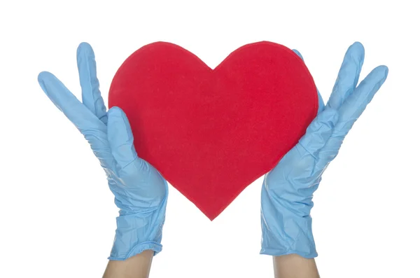 Ruce v modré lékařské rukavice udržovat srdce — Stock fotografie