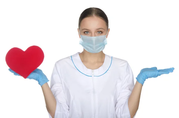 Medico donna in maschera pesa sul cuore della mano — Foto Stock