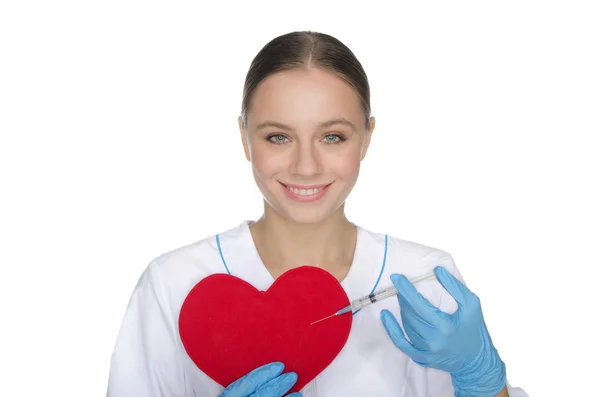 Smiling doctor with a syringe pricks heart symbol — Stock Photo, Image