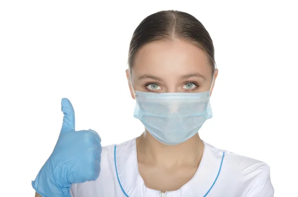 Doctor in de blauwe handschoenen en masker verhoogde duim — Stockfoto