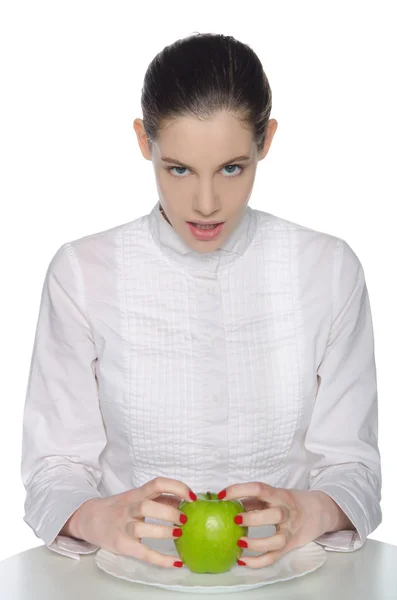 Mujer joven aprieta las uñas manzana verde — Foto de Stock