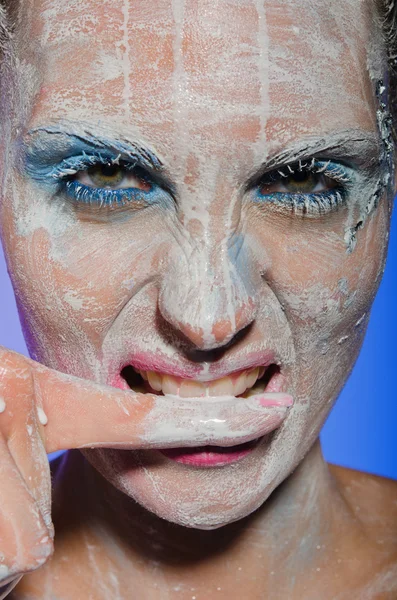 Donna con vernice sul viso che le morde il dito — Foto Stock