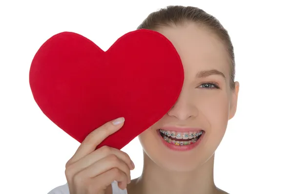 Счастливая девушка с брекетами на зубах и сердце — стоковое фото