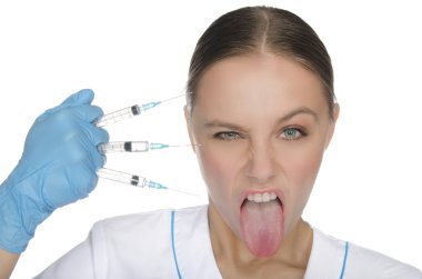 Doktor şırınga tutar ve dilini gösterir