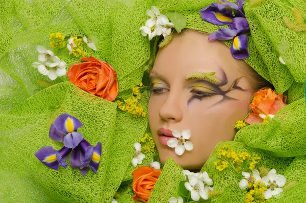 Portret van mooie vrouw in bloemen — Stockfoto