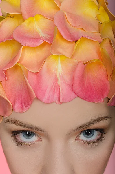 Ung kvinna med rosenblad på huvudet — Stockfoto