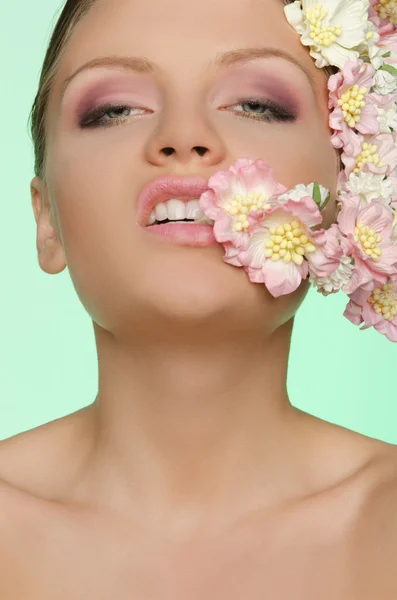 Hermosa mujer muerde flor —  Fotos de Stock