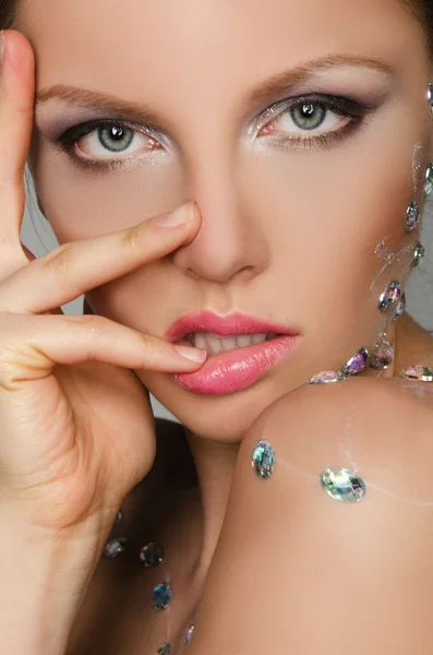 Sinnliche junge Frau mit Steinen im Gesicht — Stockfoto