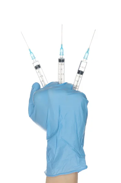 Hand in blue gloves holding three syringes — Stock Photo, Image