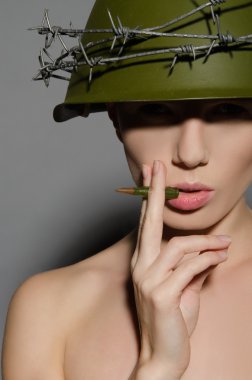 kask içinde kadın asker kurşun sigara içiyor.