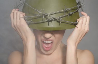 dikenli tel ile askeri kask içinde kadın çığlık atar