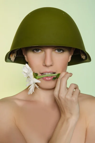 Woman in a military helmet with chamomile mouth — Stock Photo, Image