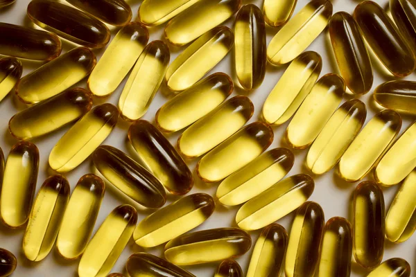 Macro of a bunch of yellow gel pills. — Stock Photo, Image